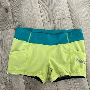 UFC neon green shorts with side pockets, has blue waistband. Size M
